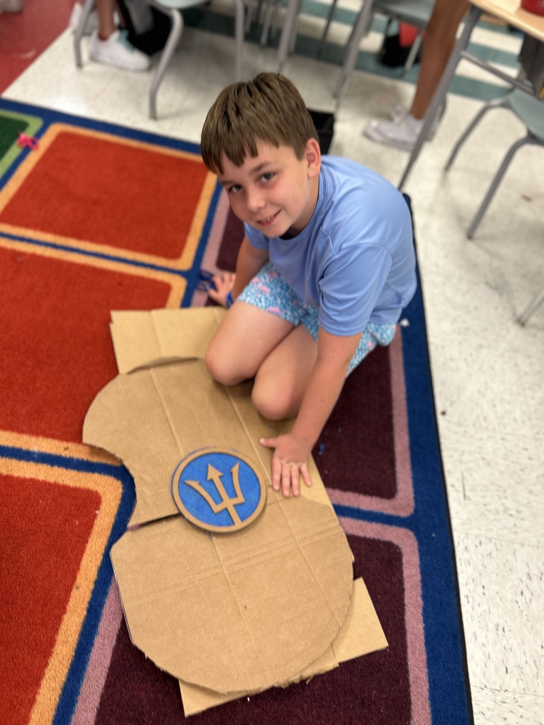 The student represents a Greek shield showing the symbol of Poseidon.