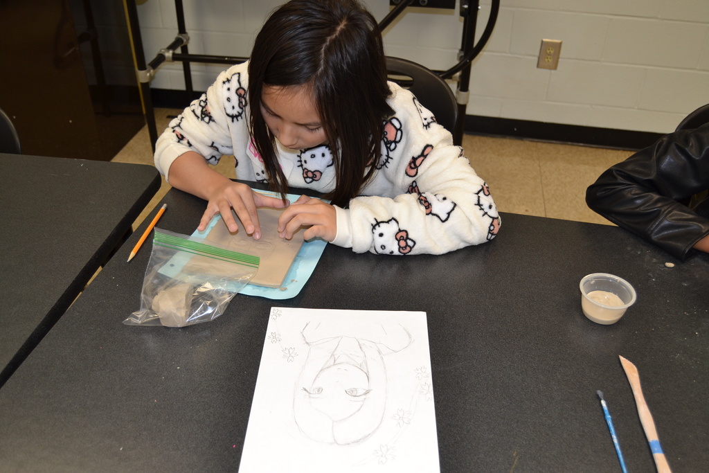 Student working on creating her clay portrait