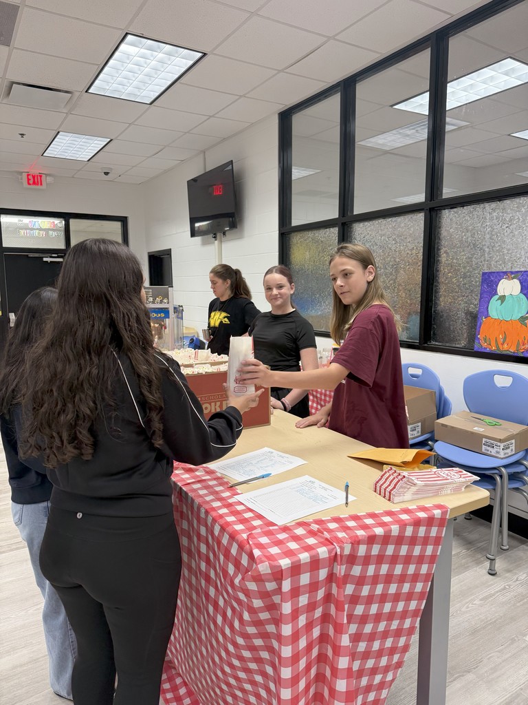 students serving popcorn