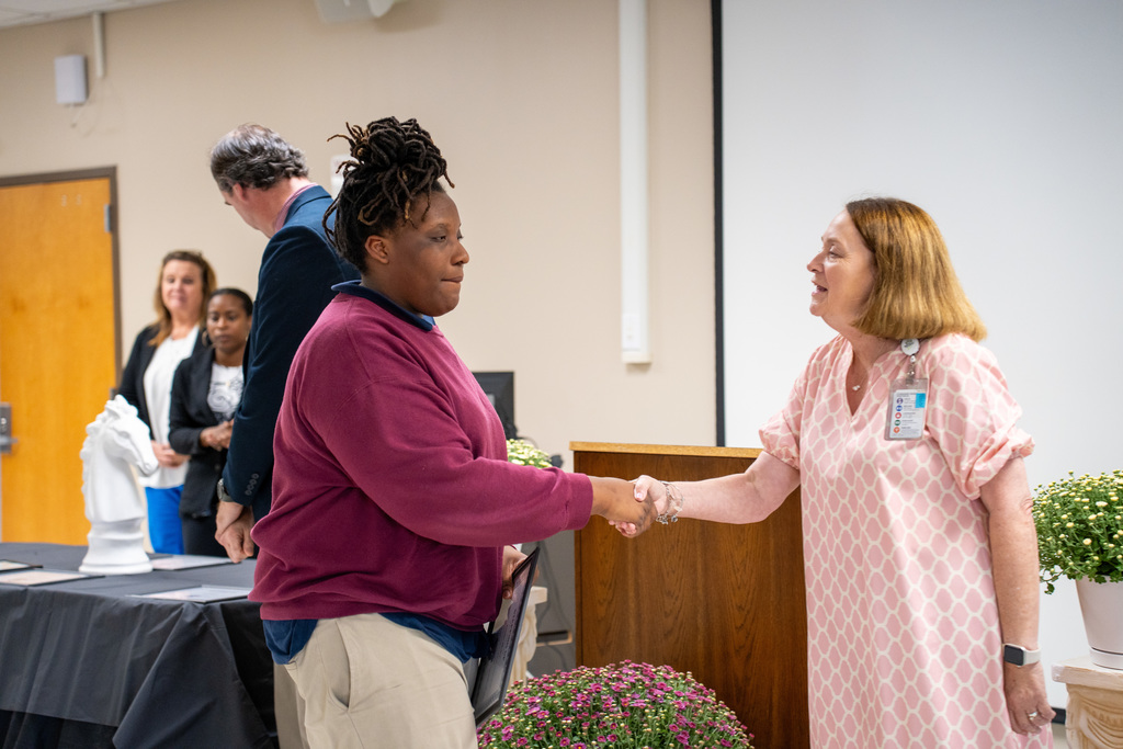 Dr. Whitley shaking student's hand