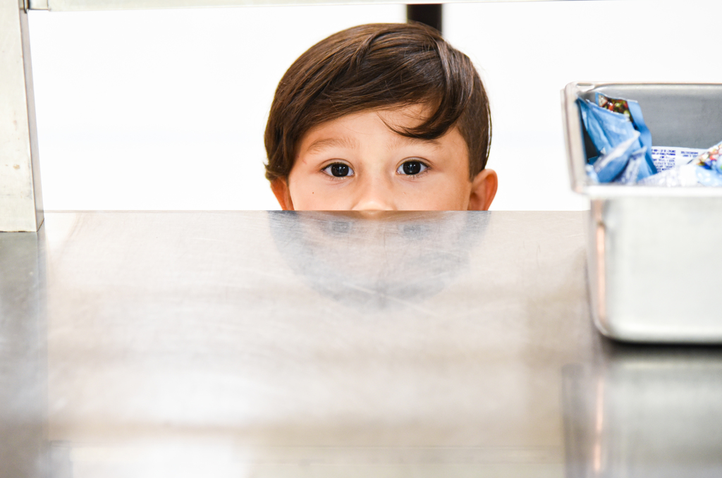 student peeking over counter