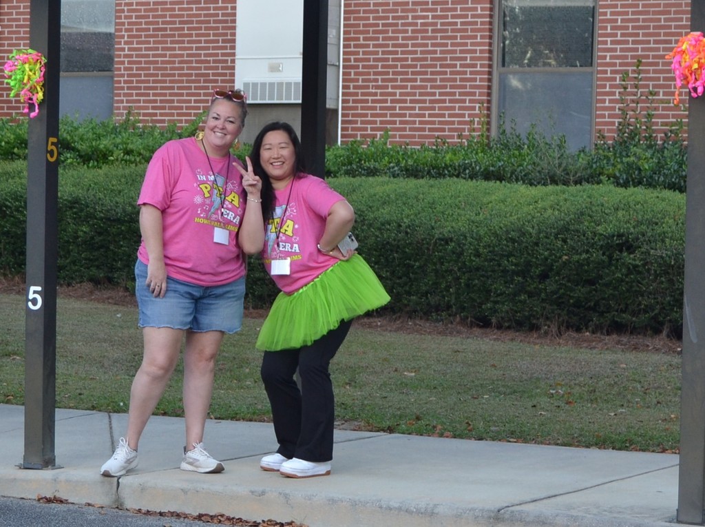 Two women posing for a picture. One is holding up the peace sign. 