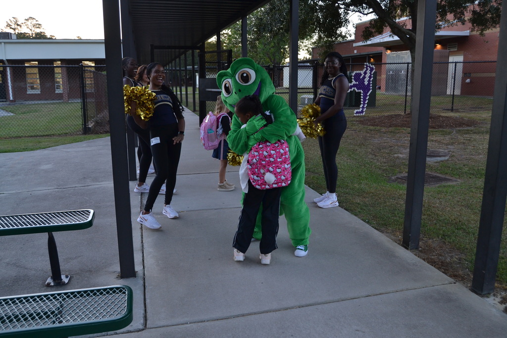 Chameleon hugging a kid with people smiling in the background