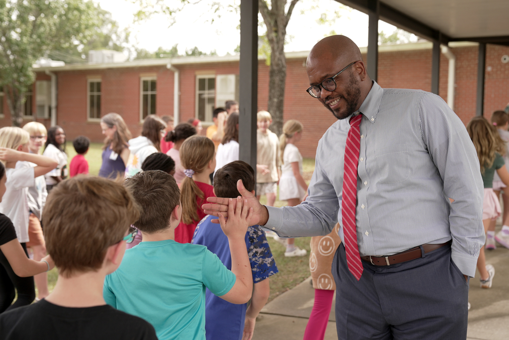 Dr. Dixon high fiving students