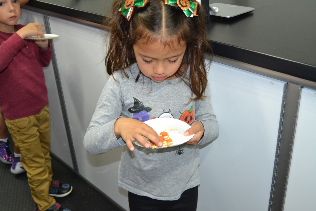 Little girl eating pizza.