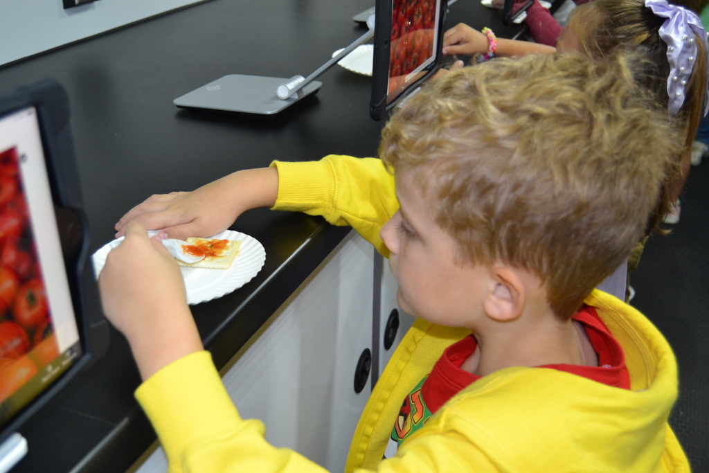 Little boy making pizza.
