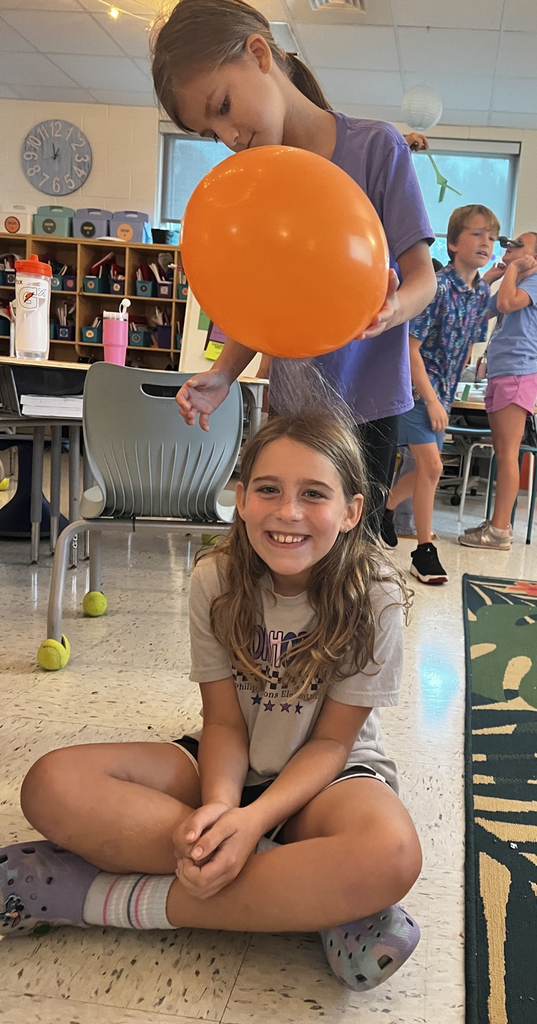 student with static electricity hair from an orange balloon