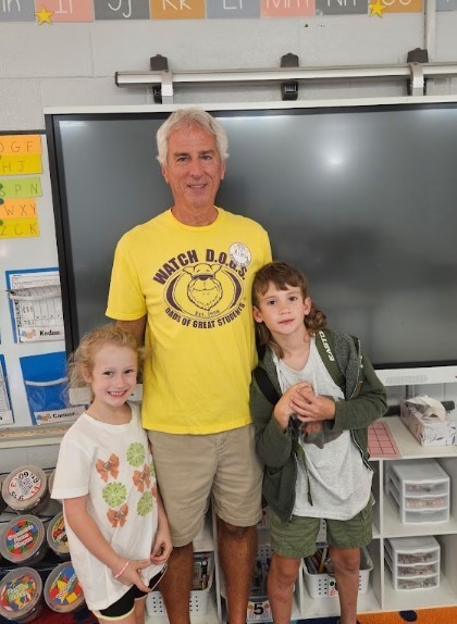 A school male volunteer with two children posing for his day with HBE as a Watch D.O.G.