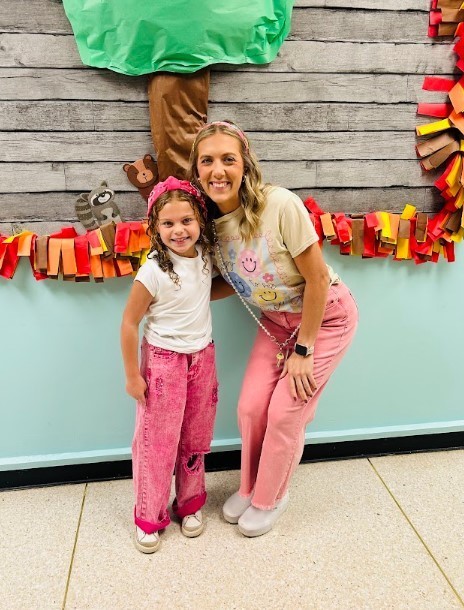 Teacher a student dressed in matching pink pants and headband for our school twin day.