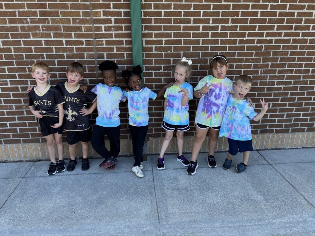 group of students making silly faces for twin day, two students in matching jersies and the other five students in tye dye