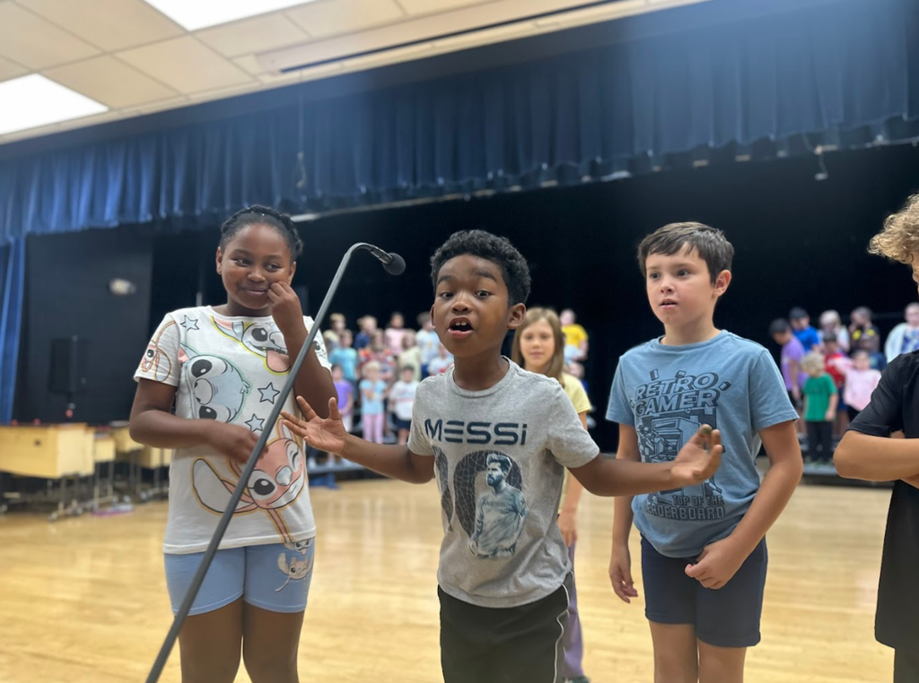 Students at microphone during a musical rehearsal