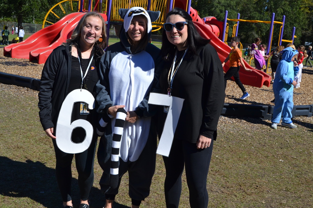 Ladies posing with a 6, 7 and a costume on