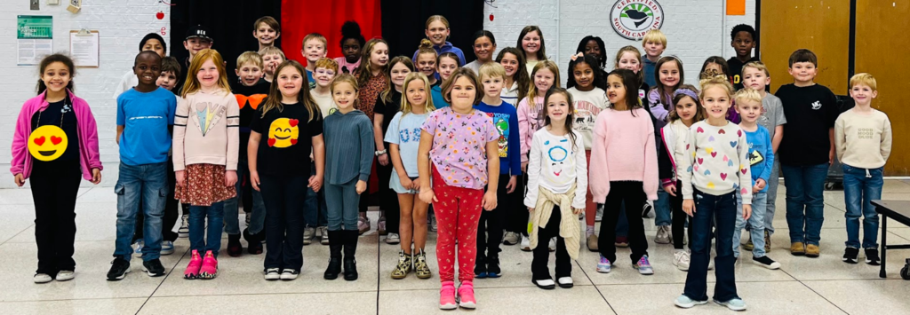 The photo includes a group photo of all of the students recognized for Terrific Kids for the character trait of responsiblity. There are 4 rows of students all standing with hands by their side and smiles on their faces. 