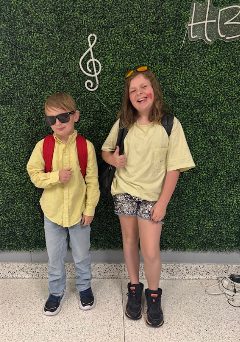 A boy and girl wearing yellow shirts and then their face matches that of their emotion. Young boy is wearing sunglasses and little girl has heart beside her lips to show the kiss emoji. 