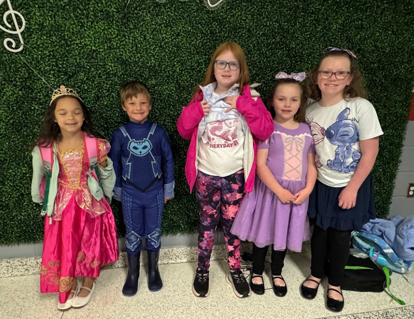 Five students dressed in Disney dresses, costumes, and Lili & Stich t-shirts.