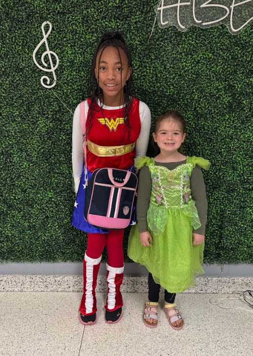Two young ladies, one dressed as wonder woman and the other as Tiana for Disney and Super Hero Day.