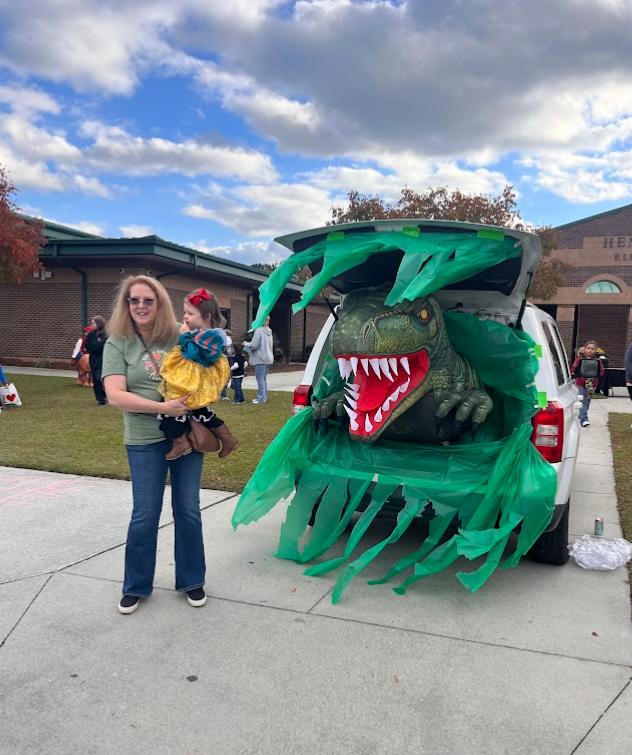 This picture includes a trunk with t-rex coming out to show the jurassic park theme at this trunk or treat.