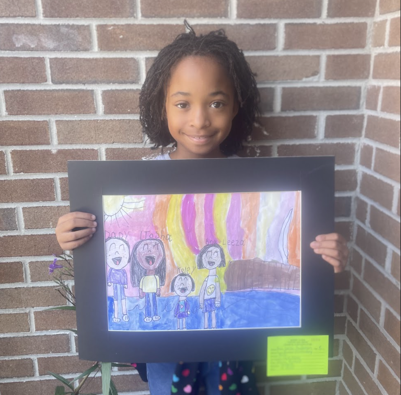 Student holding artwork (family portrait) 