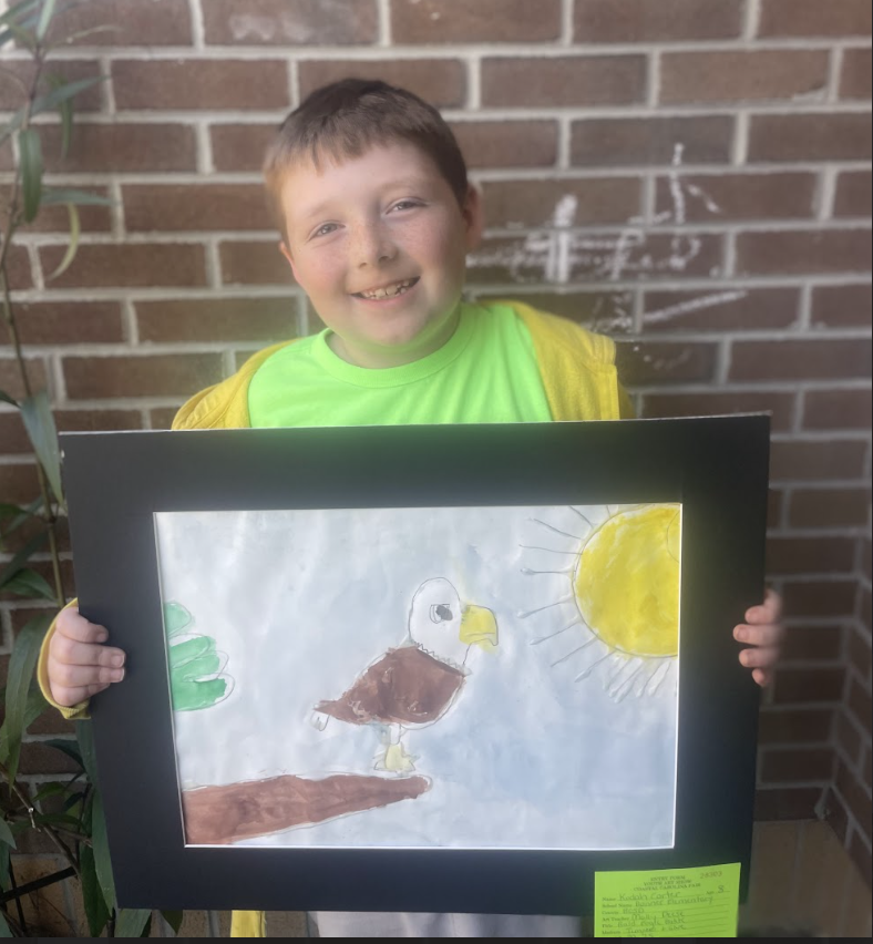 Student holding artwork (watercolor animal) 