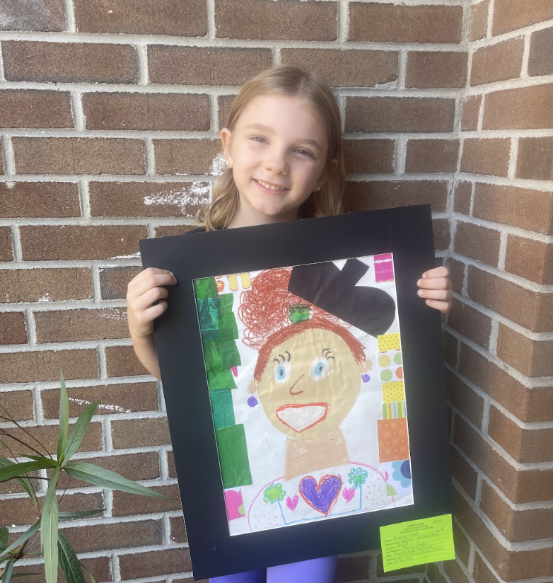 Student holding artwork (self portrait) 