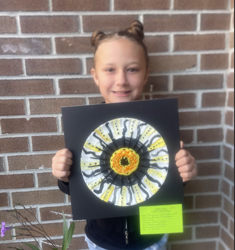 Student holding artwork (weaving pattern) 