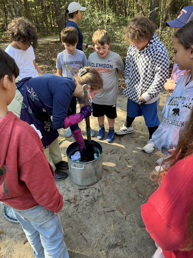 Students watch their shirts get dyed in indigo.