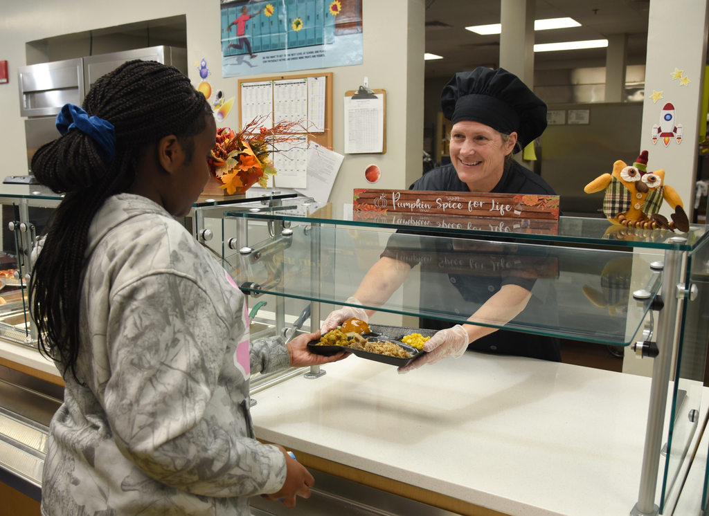 cafeteria worker handing over tray