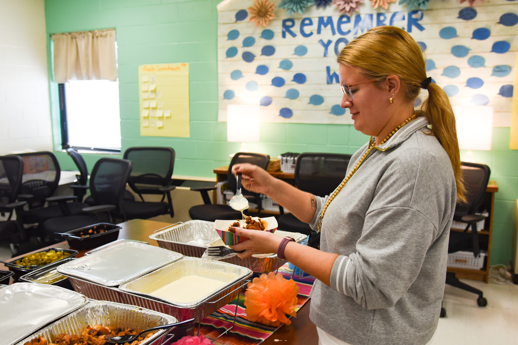 teacher putting cheese on nachos