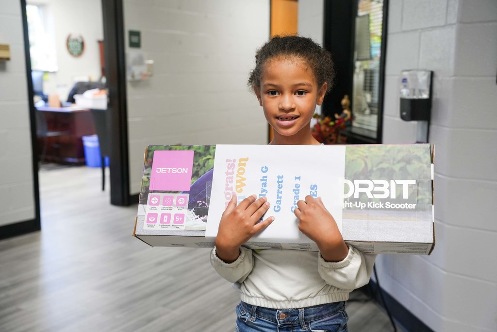student smiling with prize