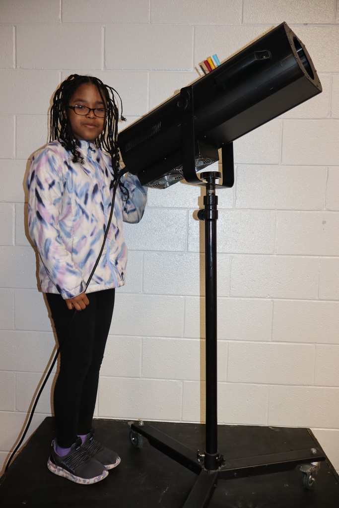 One female student operating the spotlight 