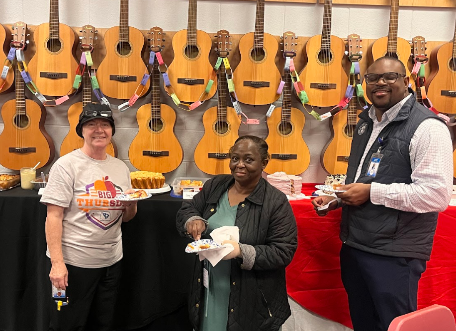 In this image is a picture of HBE's three Bonner Bake off judges. Pictured from left to right is the cafe manager, Mrs. Pam, in the center is HBE's powerschool clerk, Ms. Dingle, and all the way to the right is Mr. Jerald Borden. All three judges are holding plate and turned smiling for the camera.