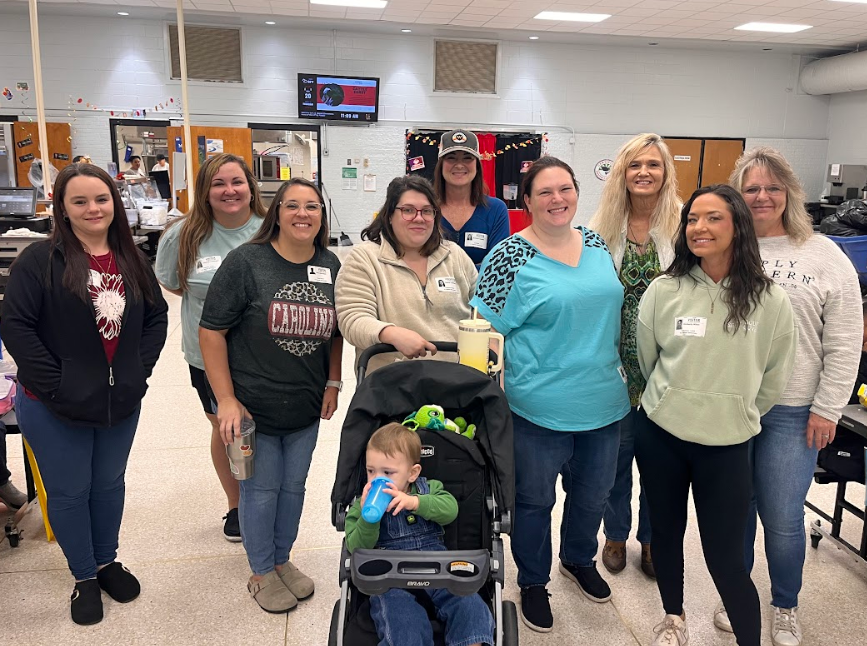 Nine of our school volunteers grouped together for a picture in the school cafeteria.
