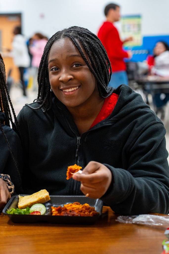 student smiling with lasagna 