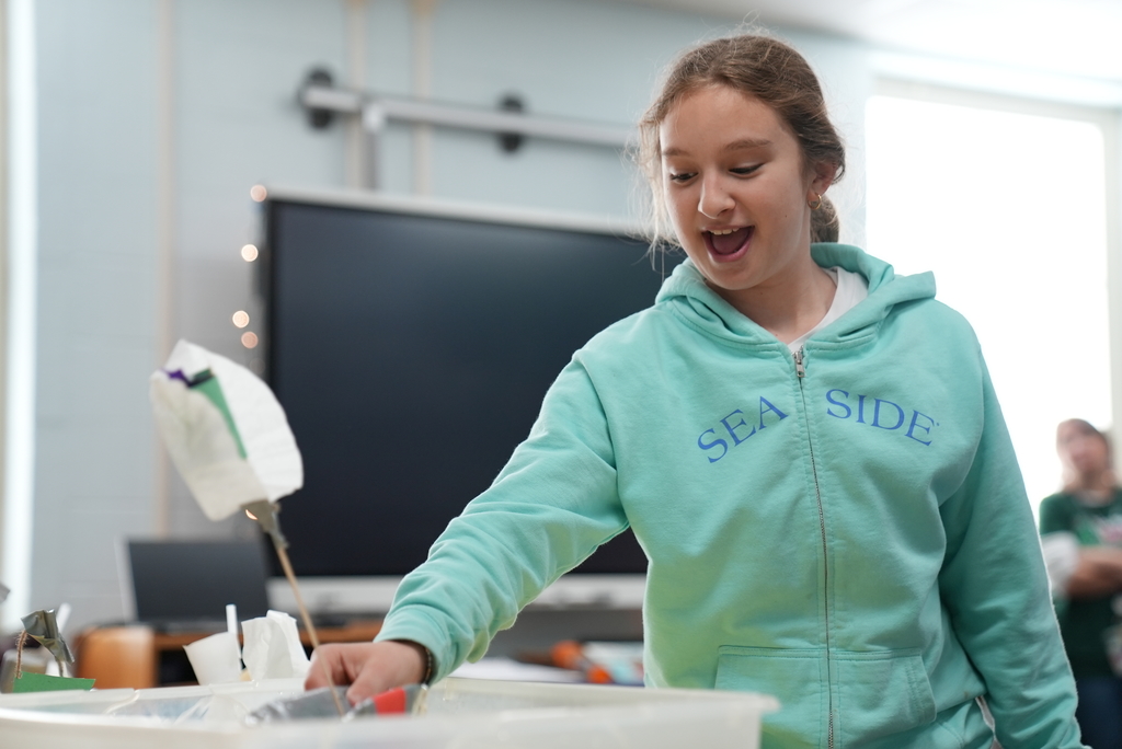 student watching boat float