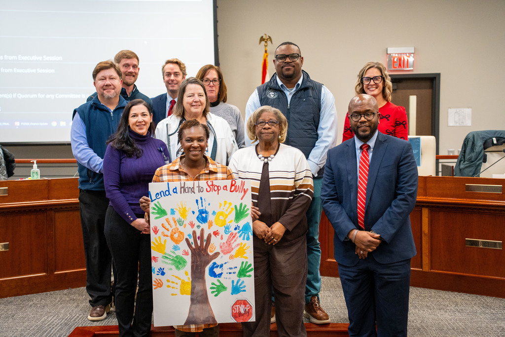 Principal with poster and board members