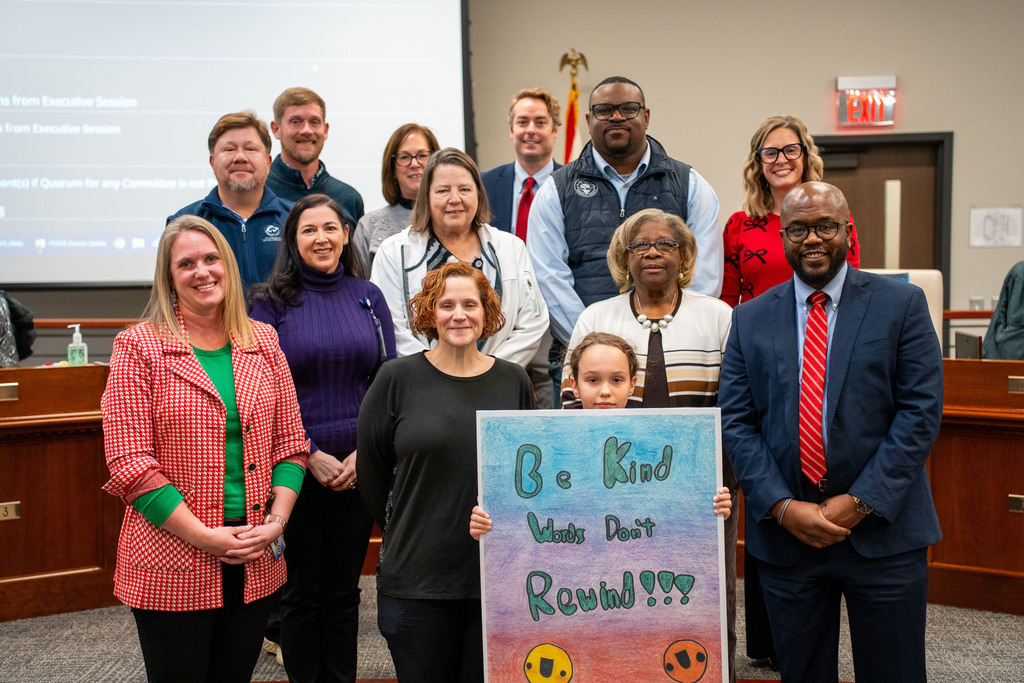 student with poster and board members
