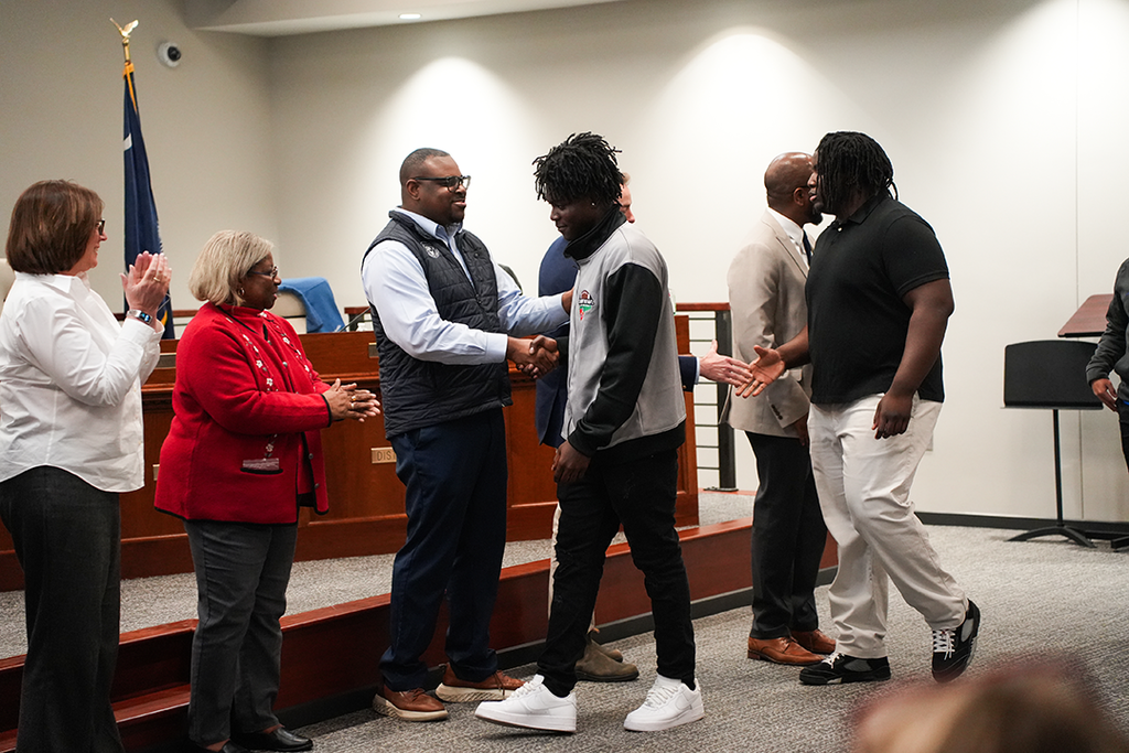 Gehad Sneed and Zion Britt shaking board members hands