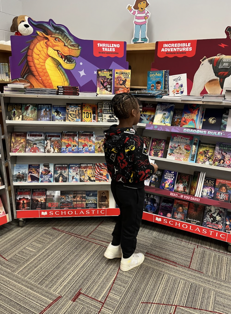 Student looking at book cases for the book fair! 