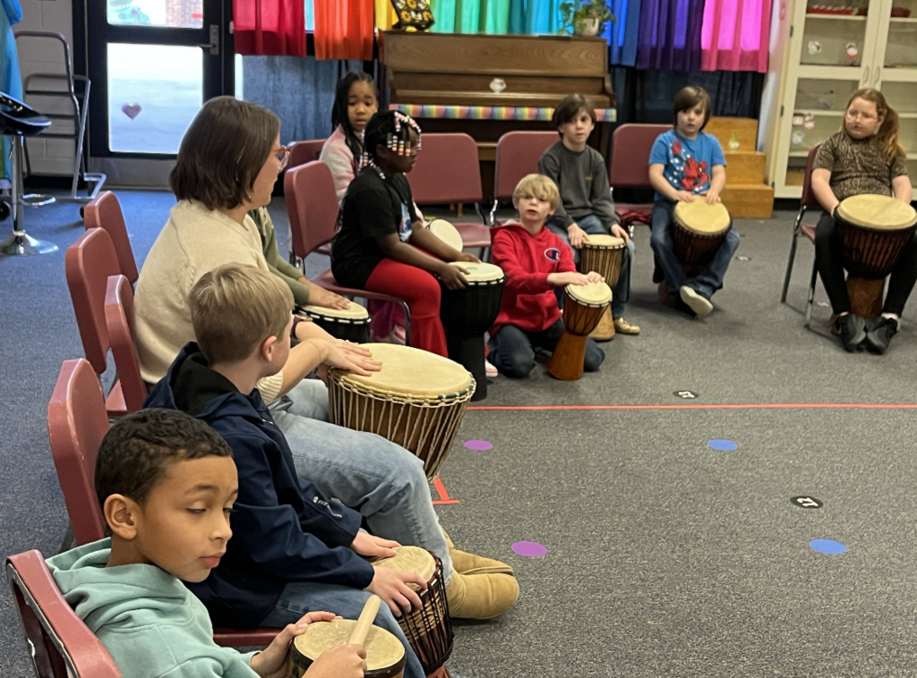 Students sitting at drums (djembes) 