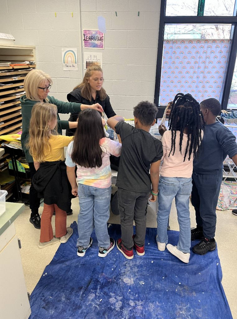 5 students indigo dyeing their piece of fabric 