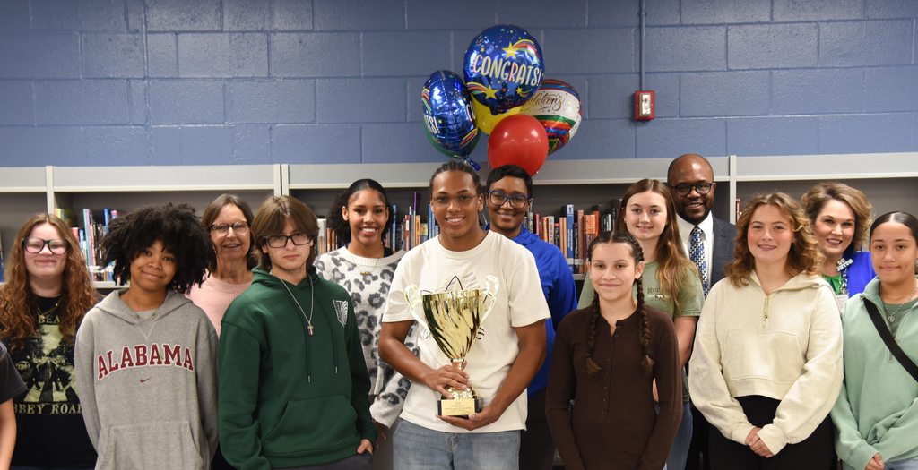 close-up of students with trophy