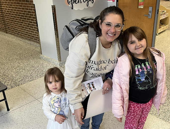 Family of three smiling standing in the hallway 