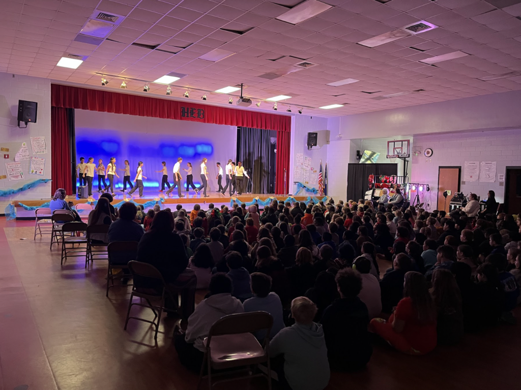 Image of a large audience with performers on stage 
