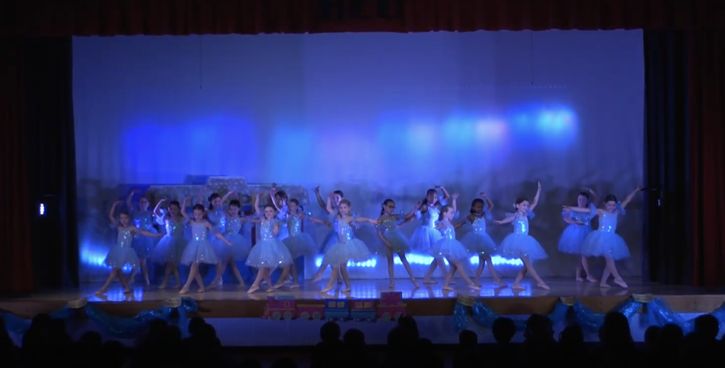 Girls in blue dresses dancing on stage