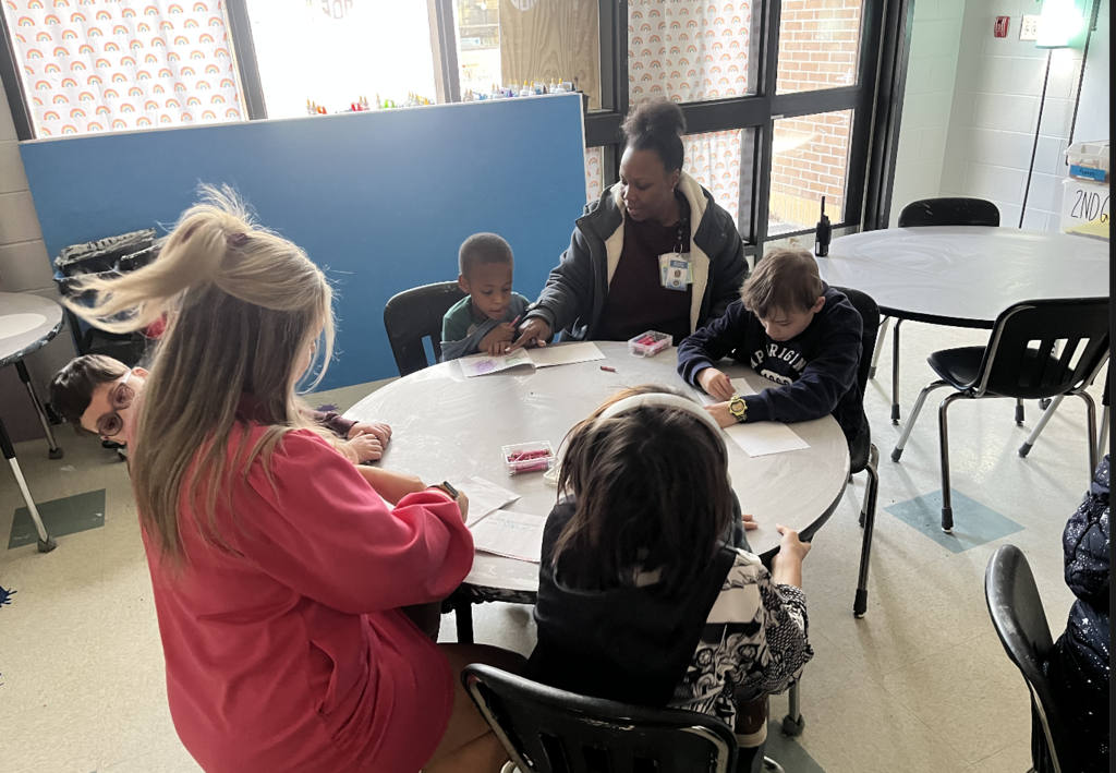 Students sitting at a table coloring