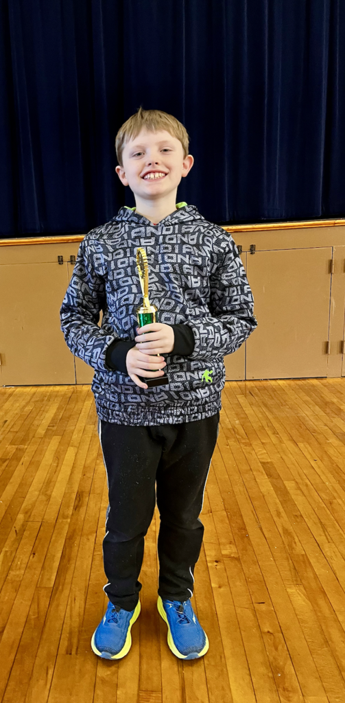 Student wearing gray hoodie holding trophy