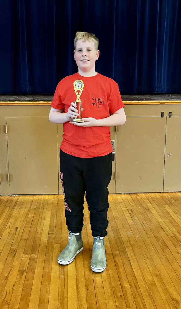 Student wearing red shirt holding trophy