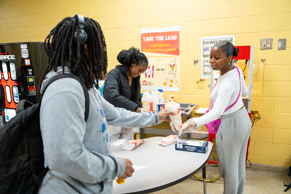 student handing other student popcorn