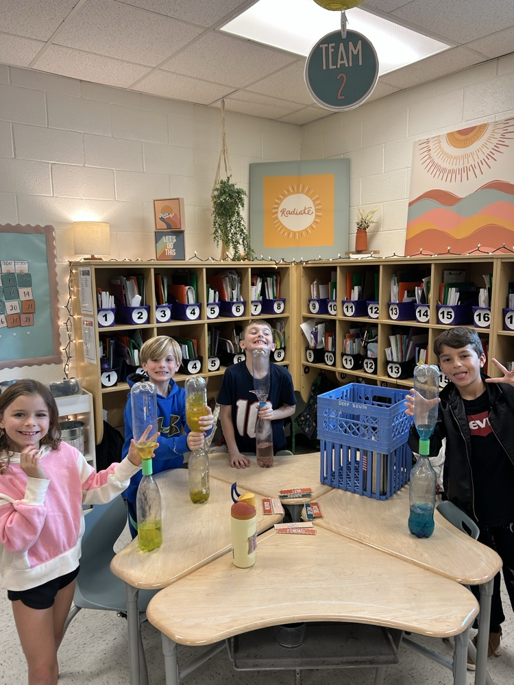 students holding tornado bottles 