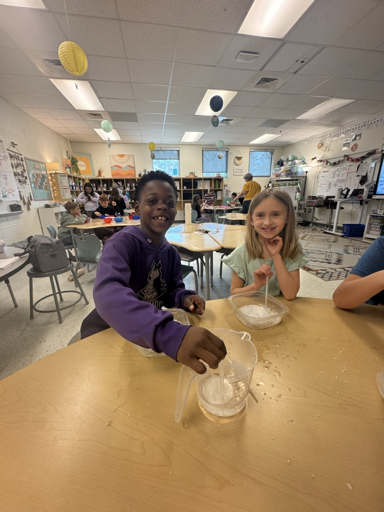 boy in purple working on science  experiments